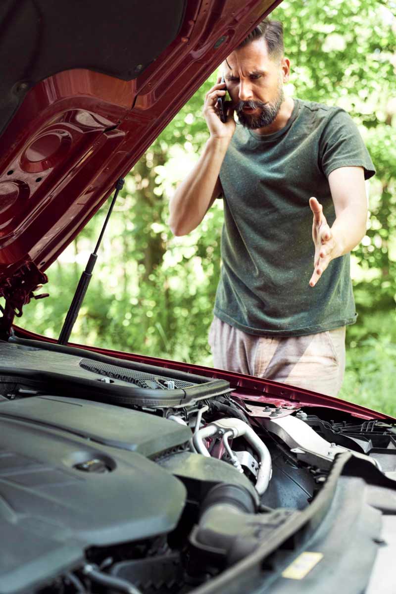 Junger Mann prüft Getriebeschaden bei Schrottauto Ankauf Marl